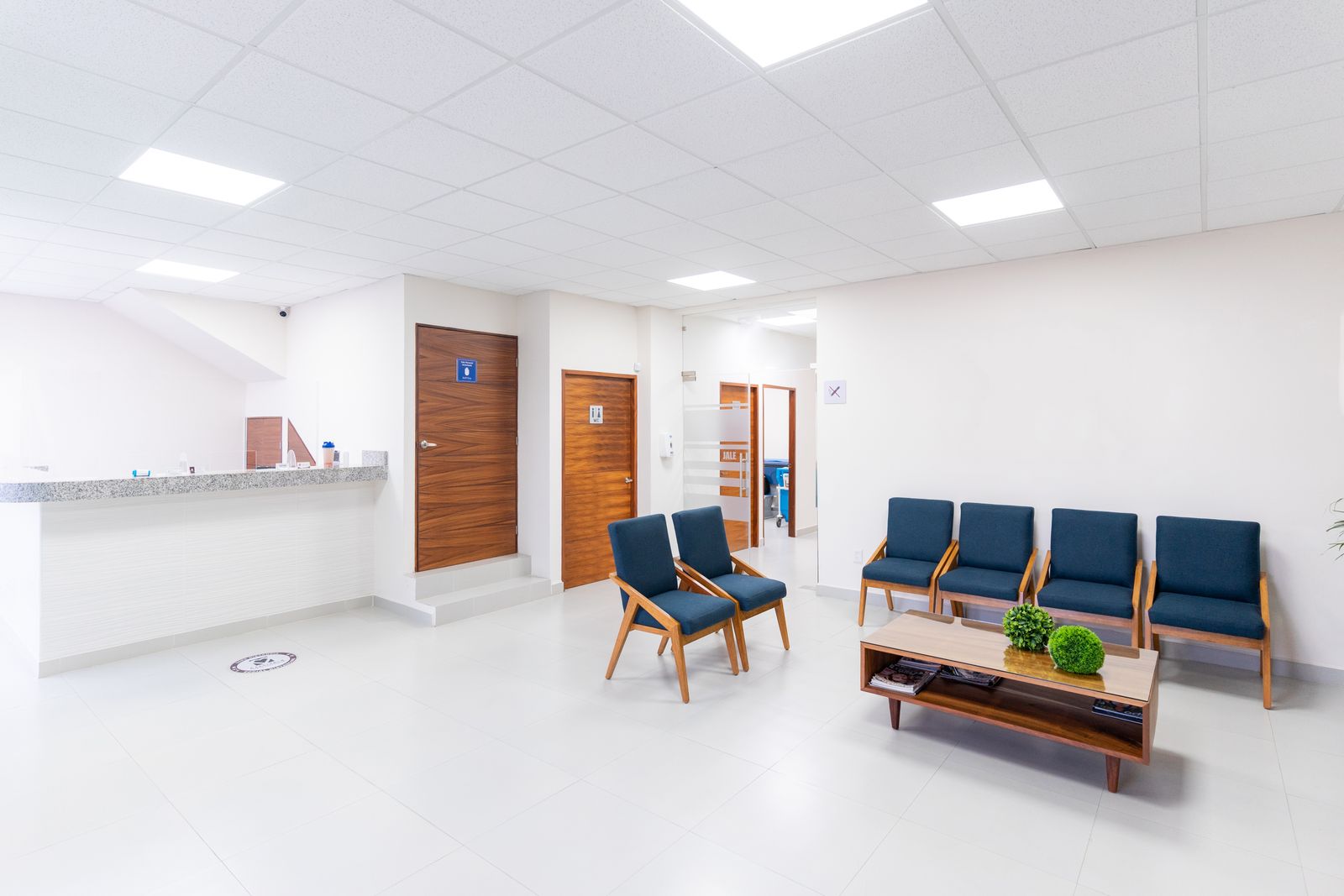An empty clinic waiting room with chairs along the wall.